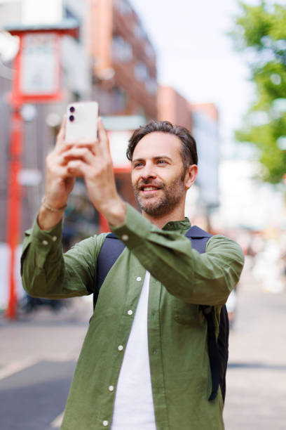 istock Caucasian man taking picture with mobile phone 1557207936