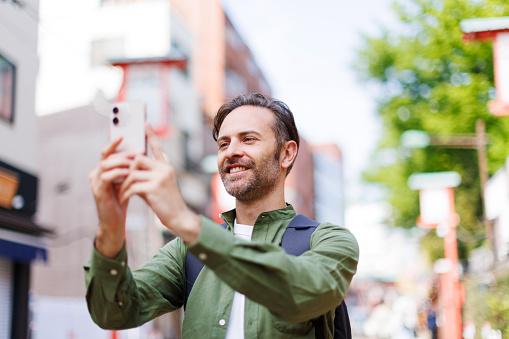 Caucasian man taking picture with mobile phone