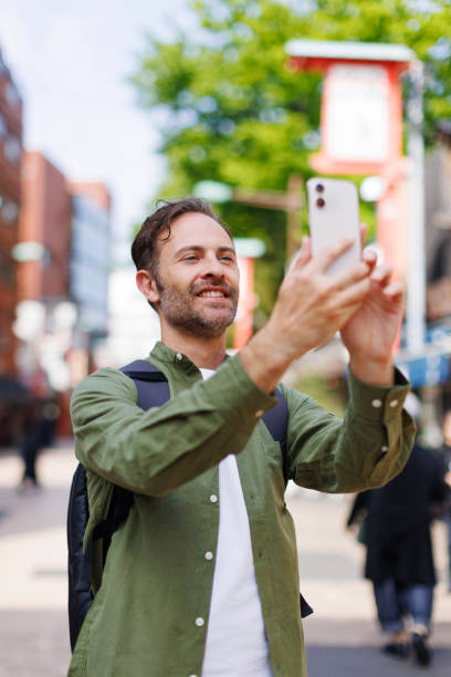 istock Caucasian man taking picture with mobile phone 1557208004