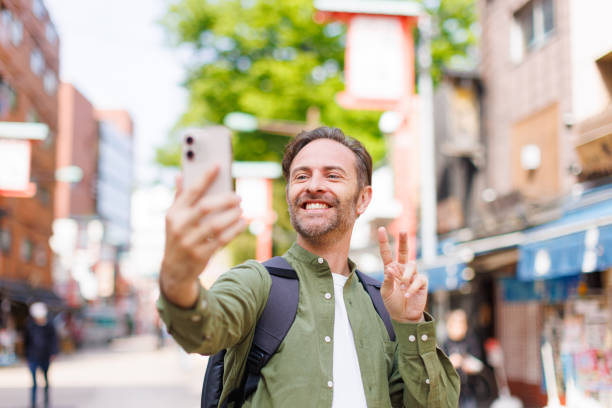 Caucasian man taking selfie with mobile phone