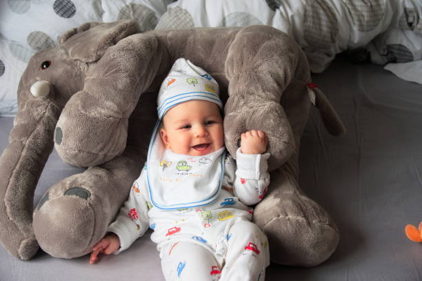 istock Baby boy with stuffed elephant toy 1557213123