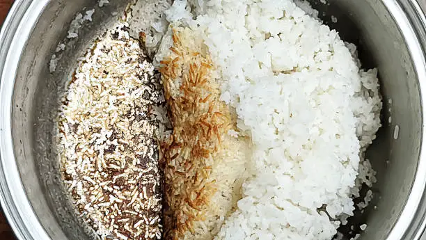 Photo of A pot of cooked rice that is burnt at the bottom.