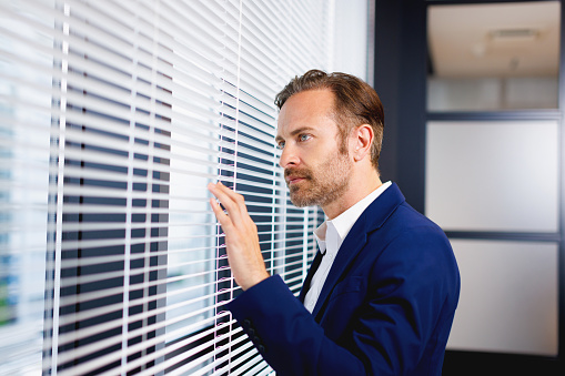 Caucasian man standing by the window in office