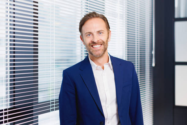 Caucasian man smiling and standing by the window in office