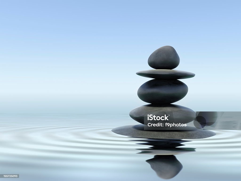 Black zen stones in shallow water Zen stones in water with reflection Zen-like Stock Photo