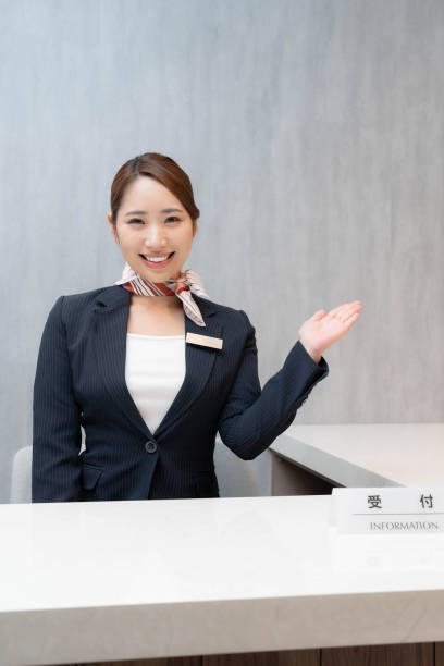 istock Beautiful Asian receptionist smiling at the camera 1557253996