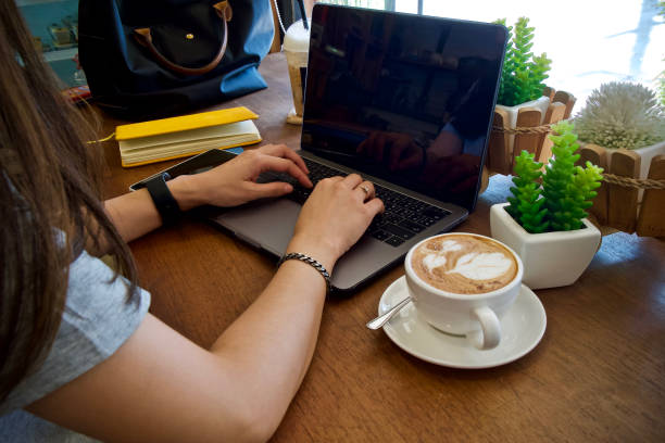 istock Women using laptop working and drink coffee cup hot 1557255579