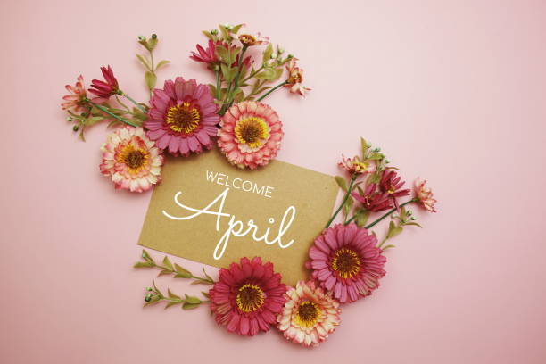istock Welcome April typography text with flowers on pink background 1557261099