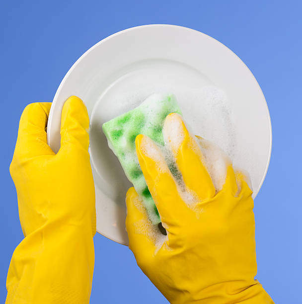 istock Hands in yellow gloves washing dish on blue background 155727371