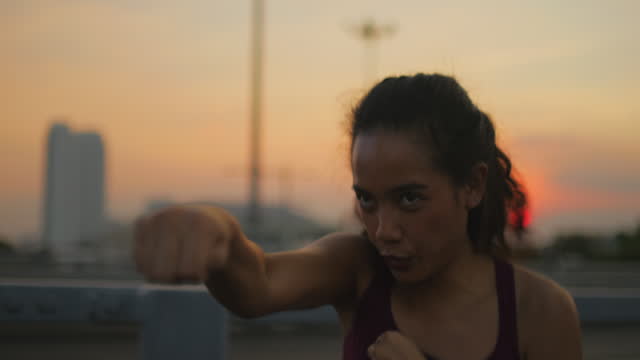 Female  doing shadow boxing in bayside public park
