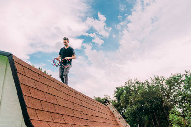 Caucasian Man on a Rooftop Pulling Red & Black Electrical Wiring for Solar Panel Installation while DIY Installing Off-Grid Power at Home