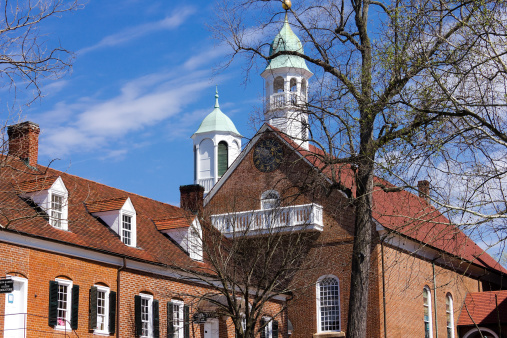 The Home Moravian Church in historic Old Salem Museum and Gardens in Winston-Salem, North Carolina USA.  The Salem College Bookstore can be seen in the foreground.
