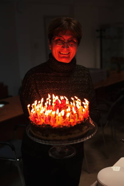 istock Senior woman holding birthday cake 1557321086