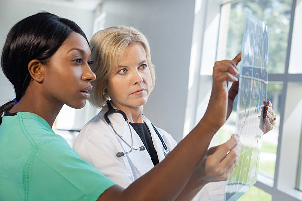 istock Female nurse and doctor looking at xrays 155732141