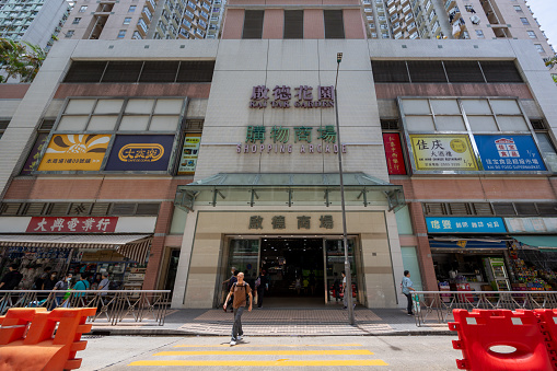 Hong Kong - July 20, 2023 : Pedestrians walk past the Kai Tak Garden Shopping Arcade in Wong Tai Sin, Kowloon, Hong Kong.