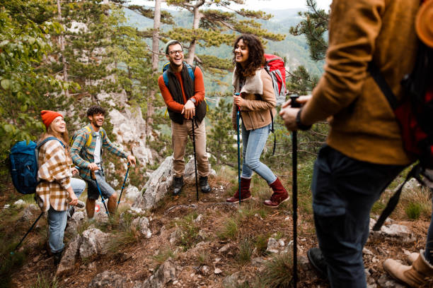 istock Cheerful backpackers talking on a rocky mountain. 1557367086