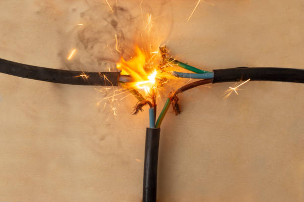 humo de llama y chispas en tres cables eléctricos conexión defectuosa, sobre fondo de madera, concepto de riesgo de incendio, primer plano - faulty fotografías e imágenes de stock