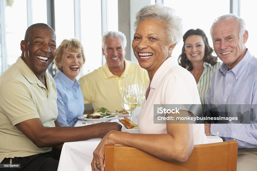 Amigos teniendo almorzar juntos en un restaurante - Foto de stock de Tercera edad libre de derechos