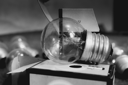 A light bulb object on top of a packaging box, a small glass light bulb.