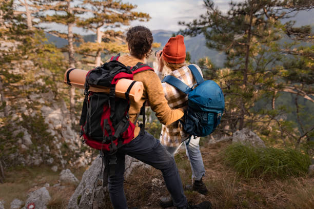 istock Back view of couple of backpackers exploring the mountain. 1557374496