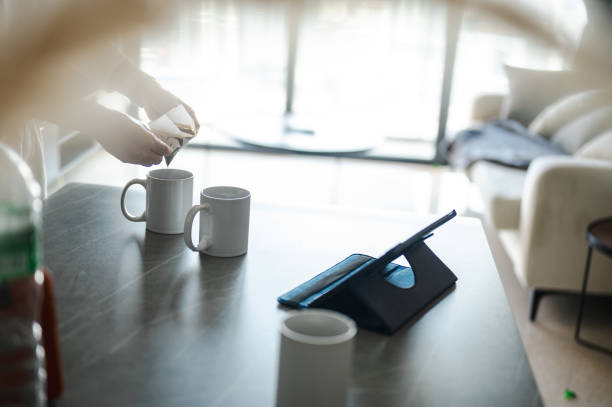 istock Making coffee with drip coffee bag in a beige cup on white marble table 1557380290