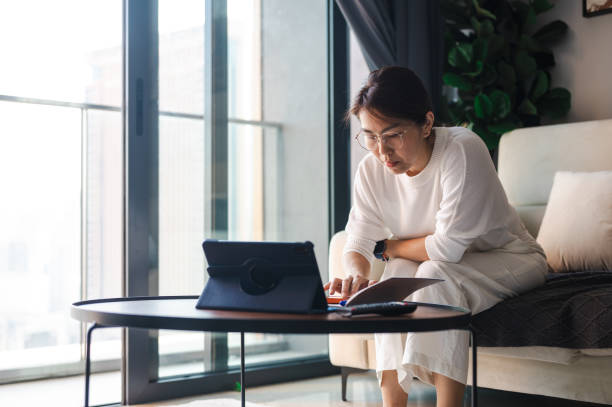 istock Sofa Savvy: An Asian Woman's Living Room Workstation 1557381905