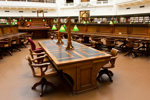 Reading room desk surrounded by wooden chairs