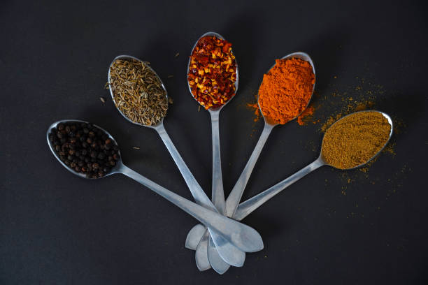 istock Colourful herbs and spices for cooking dishes on dark background 1557437731