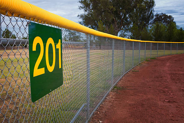 Little League Baseball Fence Little league baseball fence with a distance marker sign. outfield stock pictures, royalty-free photos & images