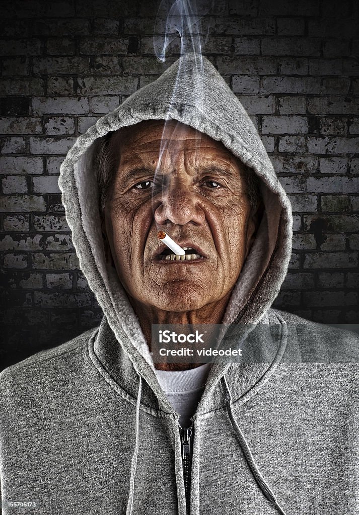 Old Hoodlum Smoking in Alley An old looking thug smoking a cigarette Mafia Stock Photo