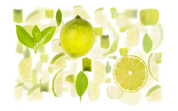 Abstract background made of Lime fruit pieces, slices and leaves isolated on white.