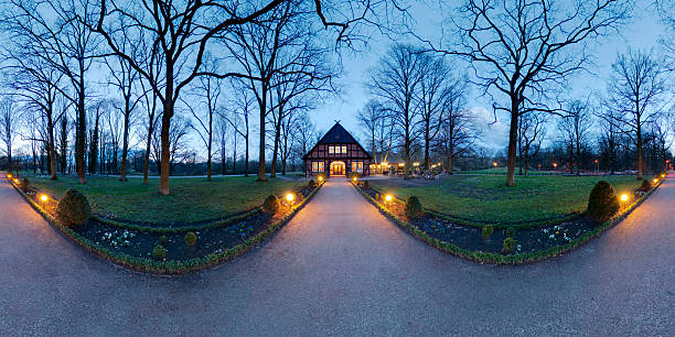 Lonely timberframe small house in city park. 360 degree panoramic composition made in november evening.