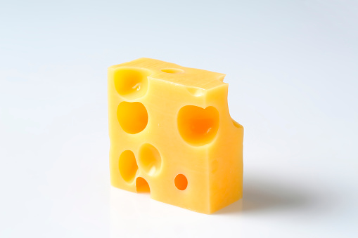 a piece of fresh emmental cheese on a white background