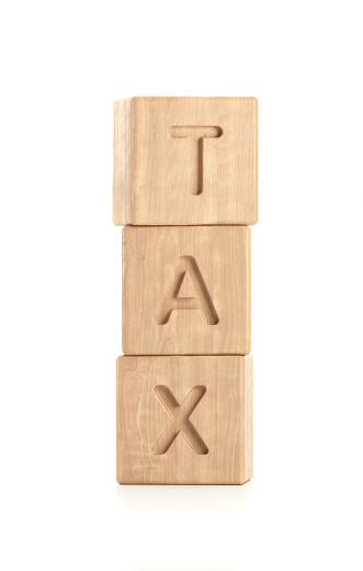Tax word made by wooden blocks on white background