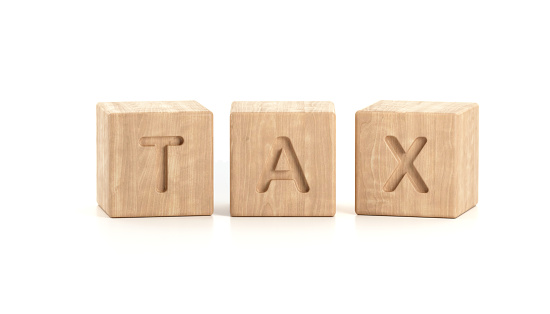 Tax word made by wooden blocks on white background