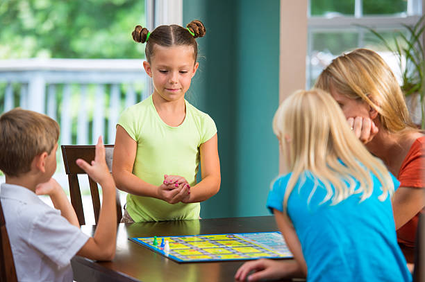 かわいい小さな女の子はボードゲーム、家族 - leisure games dice indoors table ストックフォトと画像