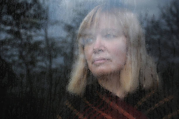 retrato de mujer a través de la ventana - condensate fotografías e imágenes de stock