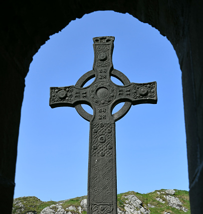 Cletic cross background. Shot in Muckross Abbey, Killarney National Park, County Kerry, Republic of Ireland. Added age effects, grain, texture. The cross is decorated with celtic knots and there is a \