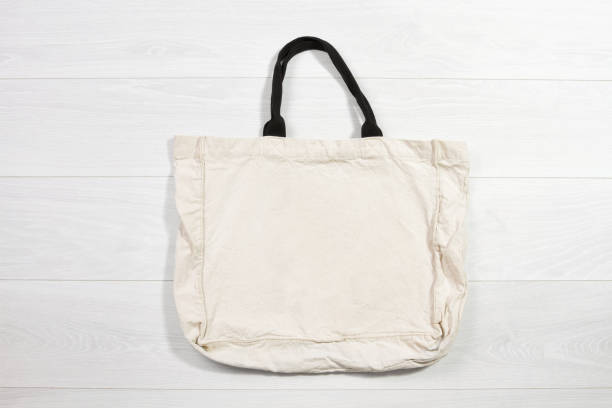 Mockup shopper handbag on wood background. Top view copy space shopping eco reusable bag. Grocery accessories. Template blank top view white cotton material canvas cloth. Empty mock-up beach fabric maqueta de bolso de comprador sobre fondo de madera. vista superior copia espacio de compras bolsa eco reutilizable. accesorios de comestibles. plantilla en blanco vista superior de algodón blanco material lienzo tela. maqueta vacía de tela de playa