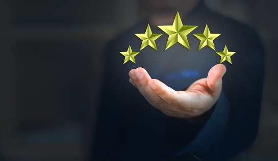 The customer's hand holds all five stars. five star rating service rating Satisfaction Concept