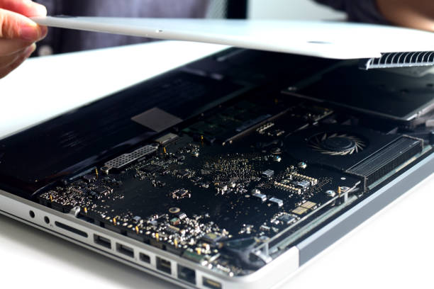 istock Technician is using to remove the cover of a notebook computer. Repairing electronic devices from deterioration and how to measure IC RAM 1557555460