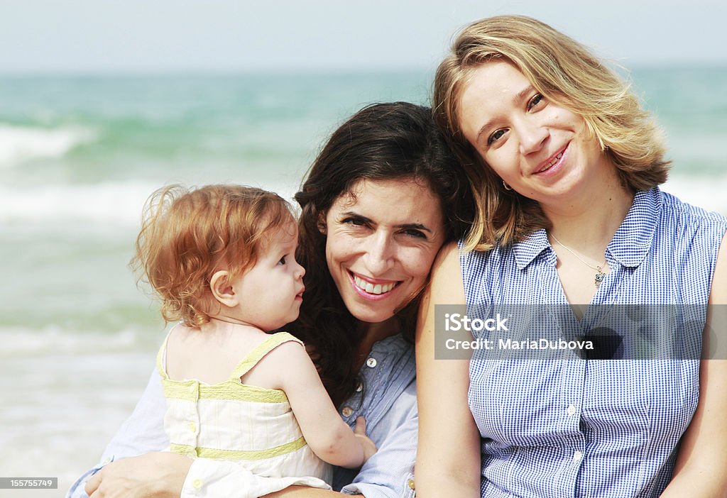 happy family two beautiful girls with a baby on the beach Family Stock Photo