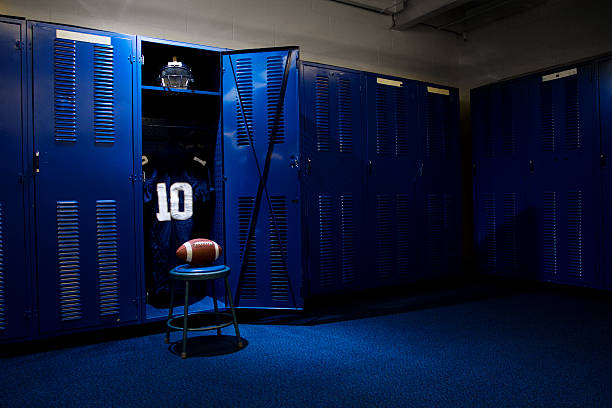 Football Locker Room An open locker with a jersey, helmet and ball in a authentic football locker room locker room stock pictures, royalty-free photos & images