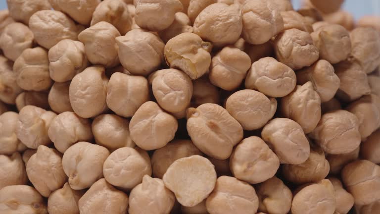 Chickpeas fall against the blue sky and fill the entire space. Close-up. Slow motion.