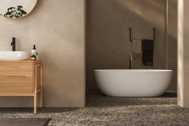 istock Beige bathroom interior with wooden vanity, bathtub, terrazzo floor 1557590110