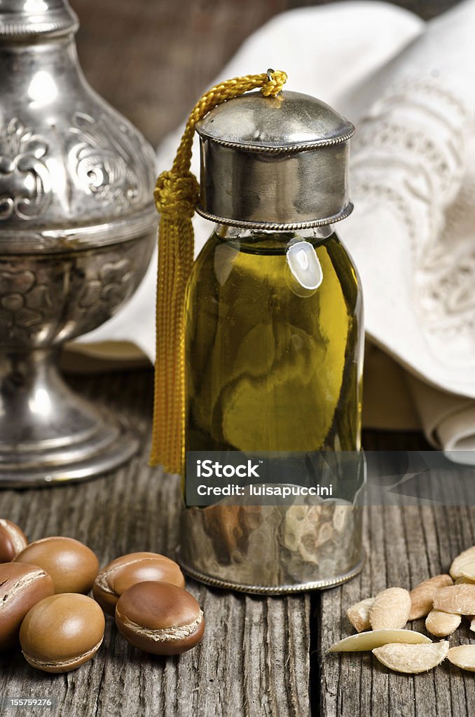 Argan oil with fruits Bottle of argan oil and argan fruit. Argan oil is used for skincare products. Argan Oil Stock Photo