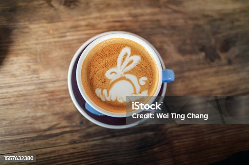 istock A cup of coffee latte with a cute bunny pattern on an old wooden table 1557632380