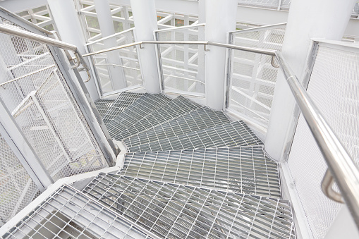 Low angle of metal stairs leading to a wind turbine access door.