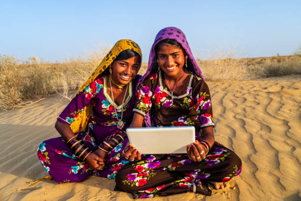 istock Happy Gypsy Indian girls using digital tablet, India 1557661872