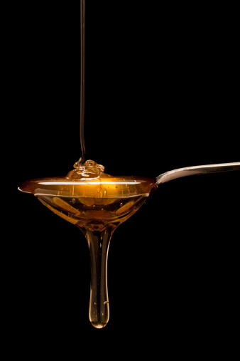 Low key image of Honey running off a spoon